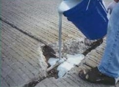 Concrete slab being prepared and coated for a waterproof garage floor